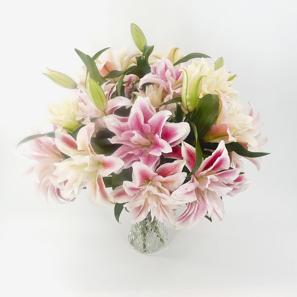 Top down view of Rose lilies bouquet in a glass vase