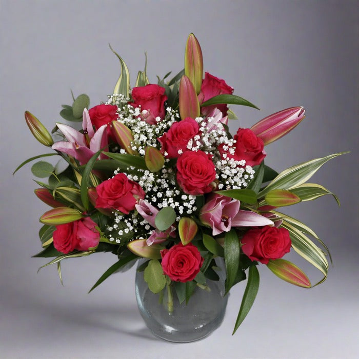 Rose and pink lily bouquet in a glass vase