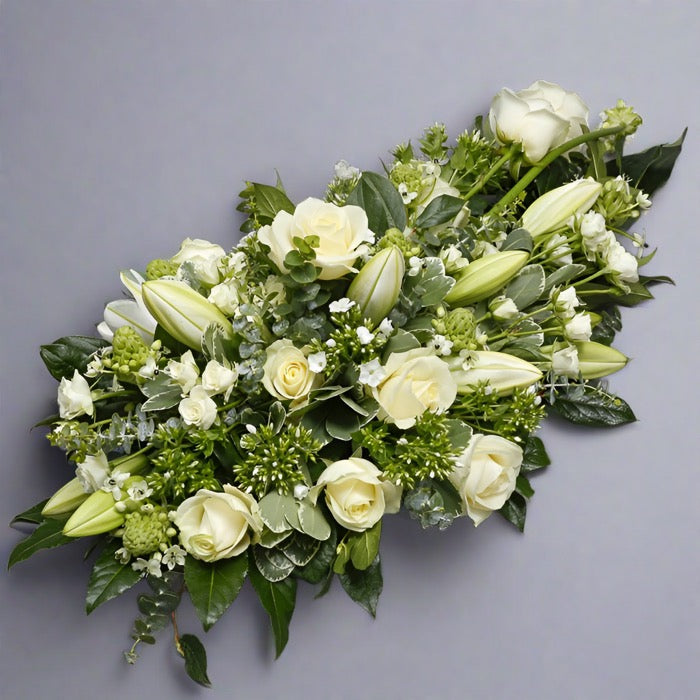 Angled view of White sympathy funeral spray