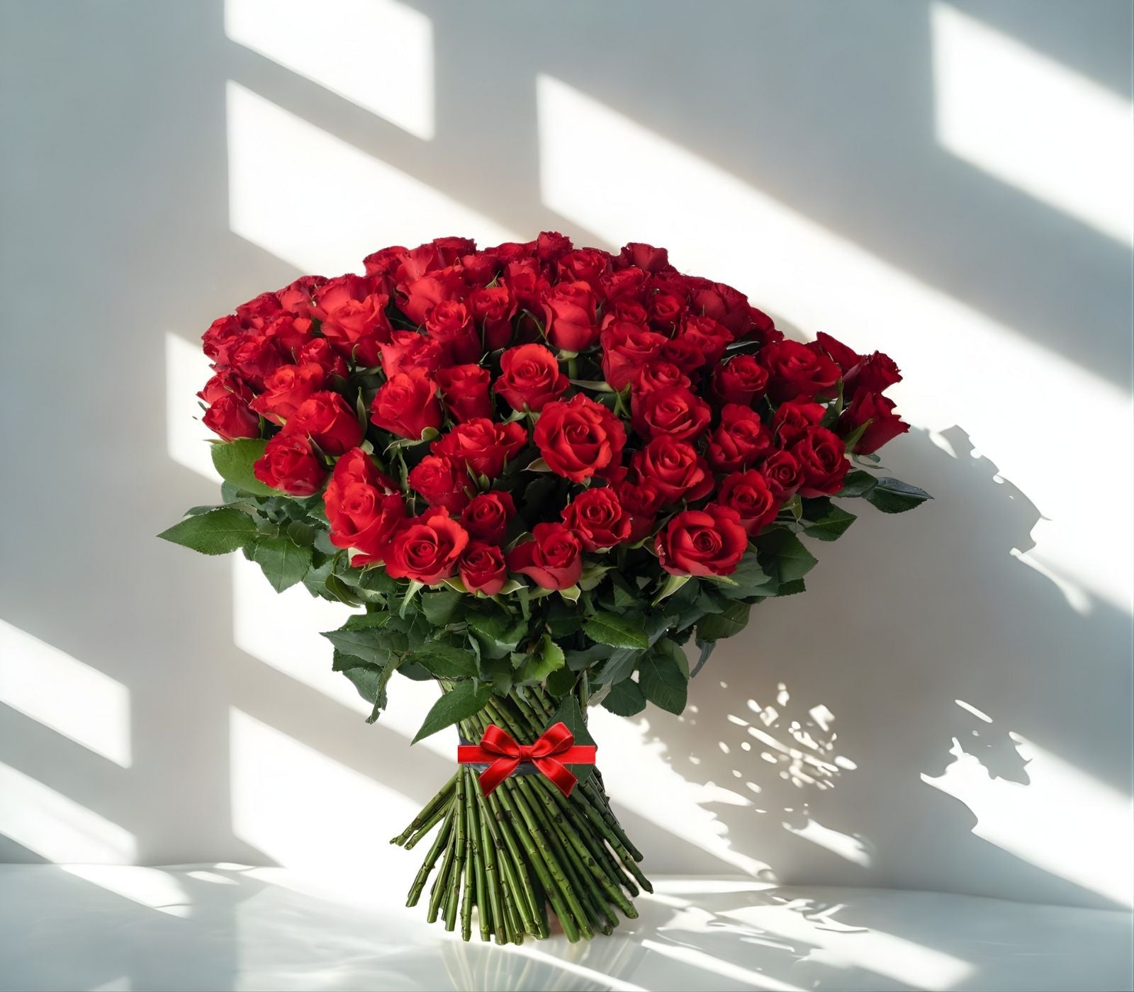 100 rich red roses madflowers bouquet delivery in Ireland on a white reflecting surface with diffused soft light and shadows