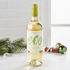 Bottle of eco wine on a white surface with Christmas decorations in the background