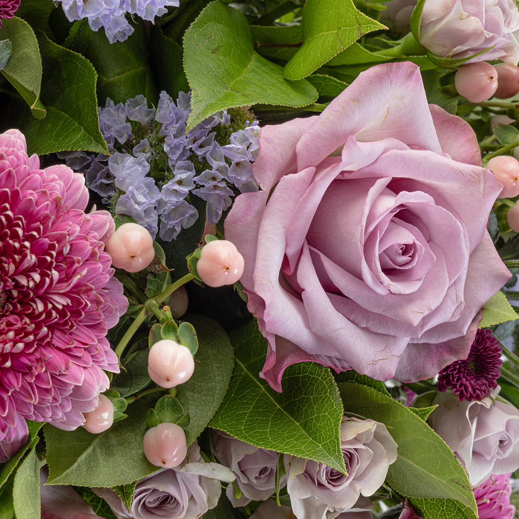 Close up view of the lavender bouquet focused on a pink rose in the arrangement