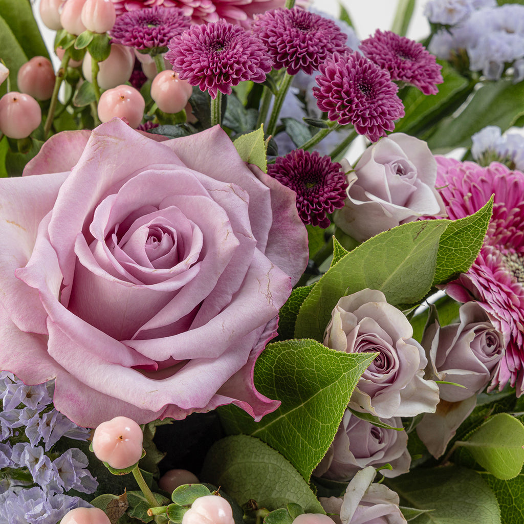 Close up view of lavender flower bouquet with roses and other floral elements