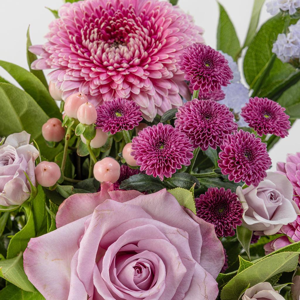 Close up view of lavender flower bouquet with shades of pink blossoms and green leaves