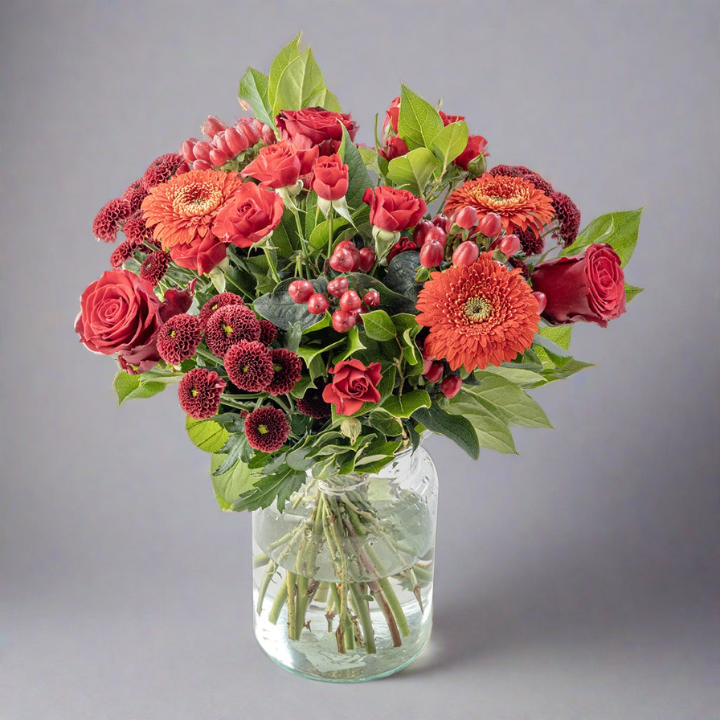 Red flowers bouquet in a glass vase