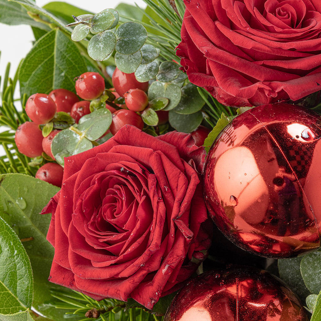 Close up view of red rose and bauble from Christmas reds tabletop bouquet