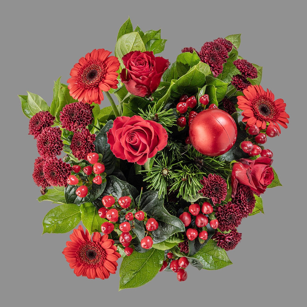 Top down view of Christmas red roses bouquet and red wine bottle and box of Heidi chocolates