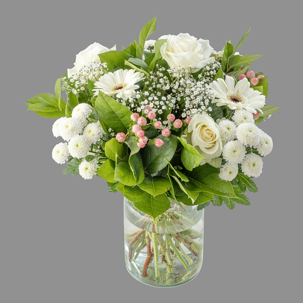A bouquet of white blossoms including roses, germini, hypericum, gypsophila, salal, and chrysanths santini in a clear vase.