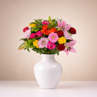 Colorful bouquet of flowers in a white vase on a light background