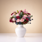 Bouquet of flowers in a white vase on a light background