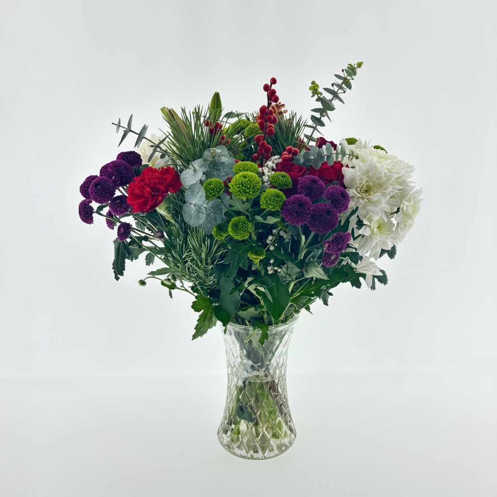 Christmas Special Bouquet of flowers in a clear vase on a light gray background