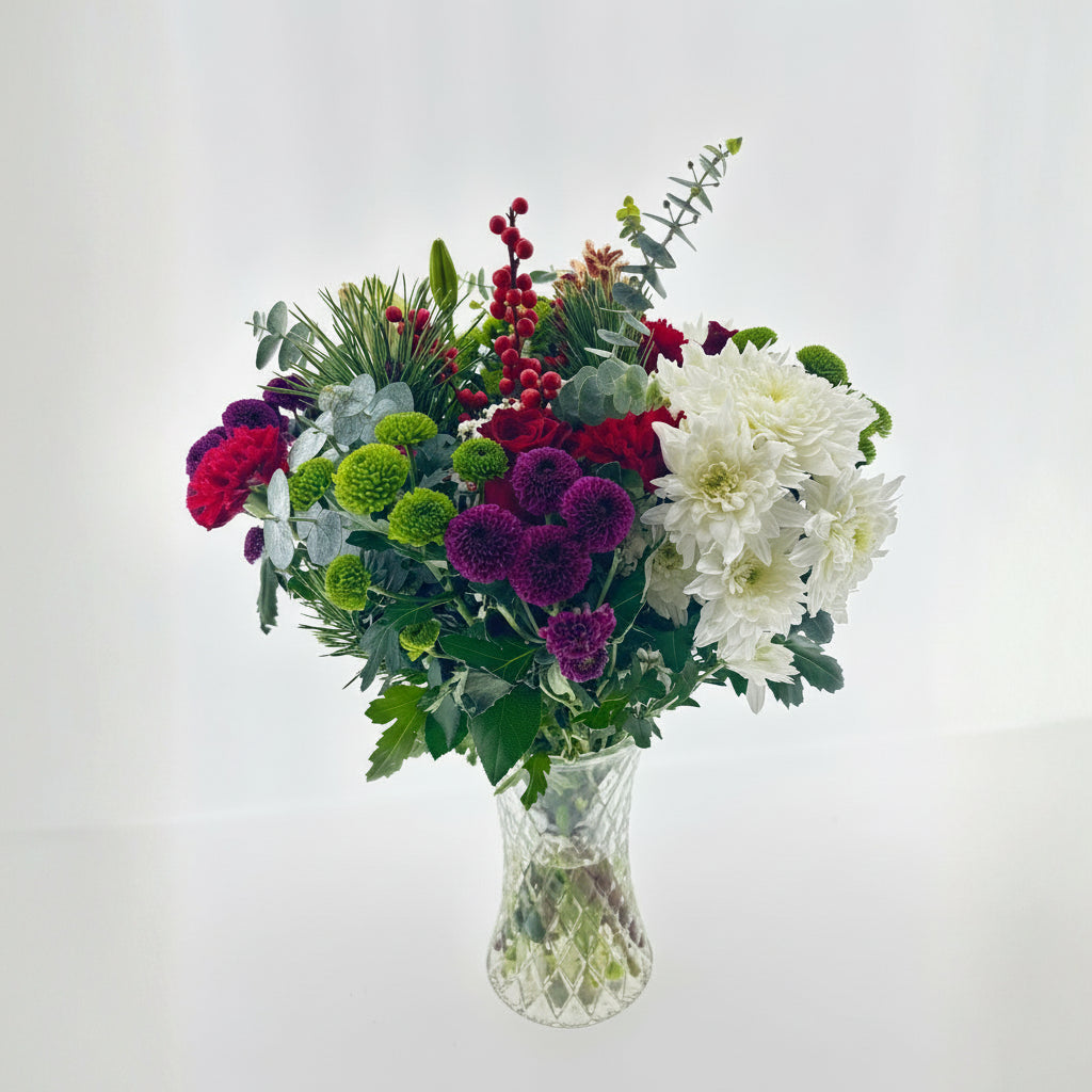Bouquet of flowers in a clear vase on a light gray background