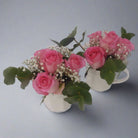 pink roses in white mugs