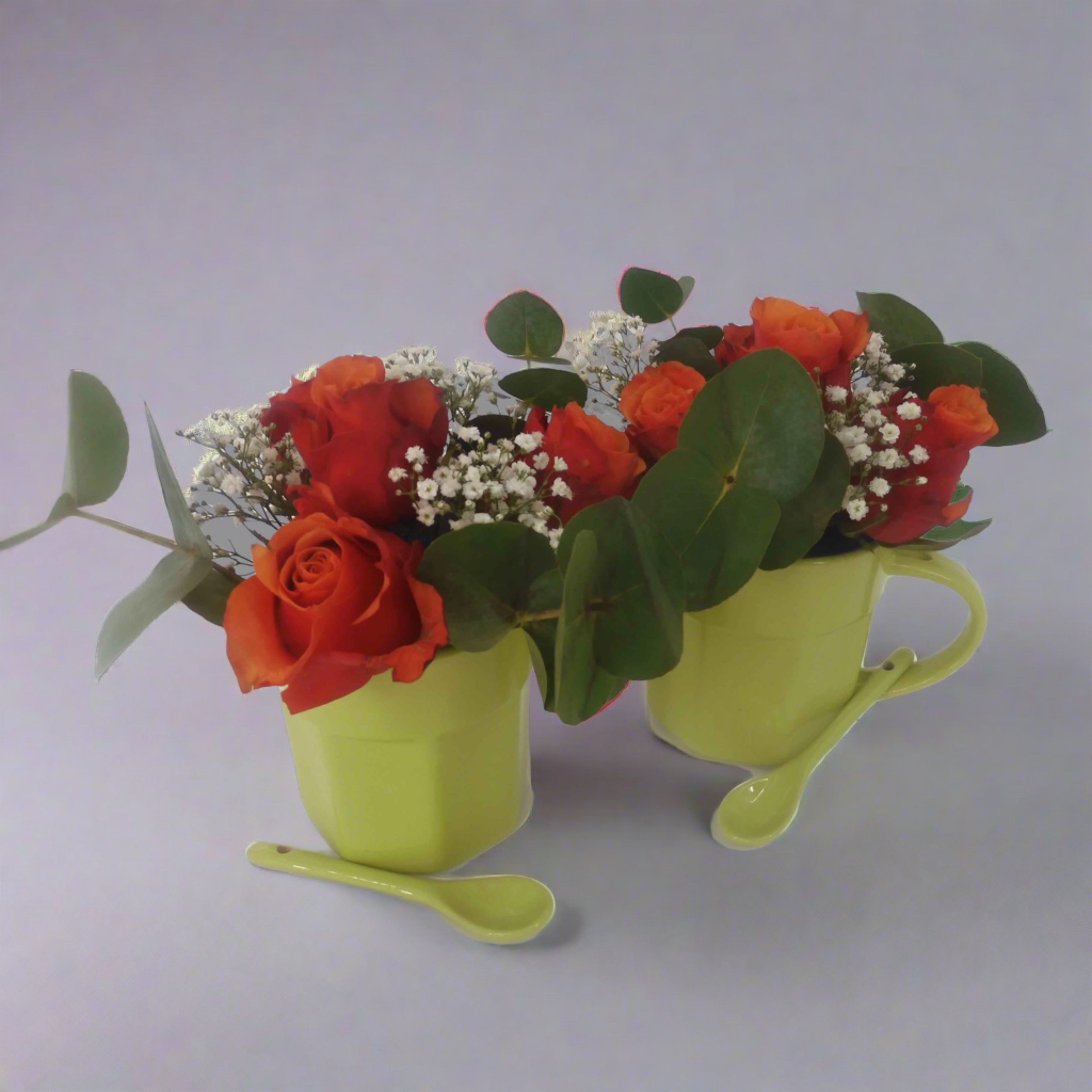 red roses in green mugs