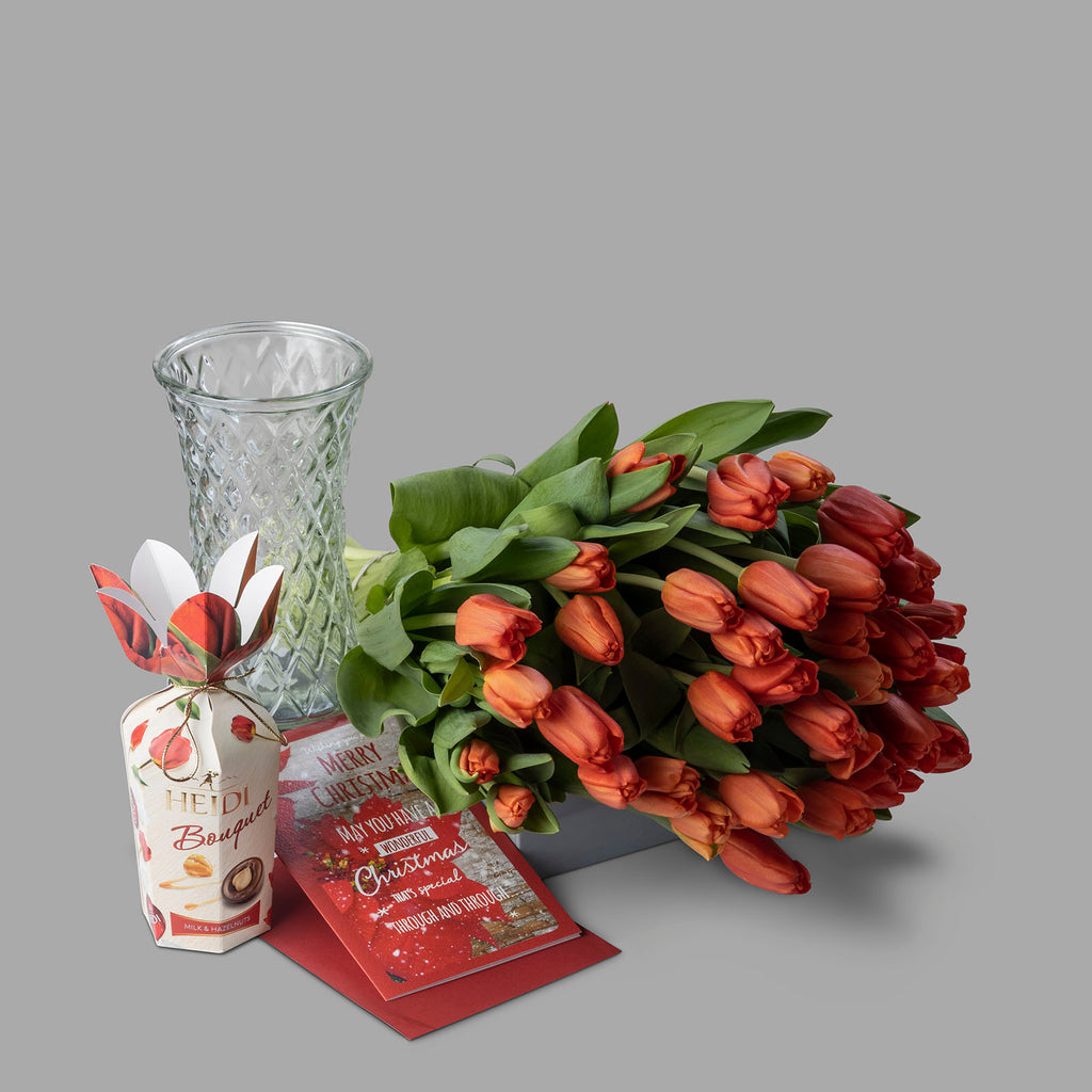 Christmas orange tulips bouquet with chocolates and a Christmas card
