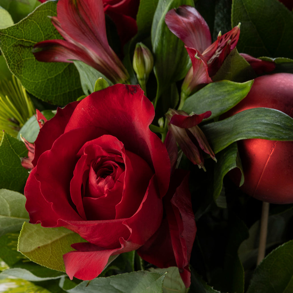 close up view of Red roses christmas bliss flower bouquet with baubles