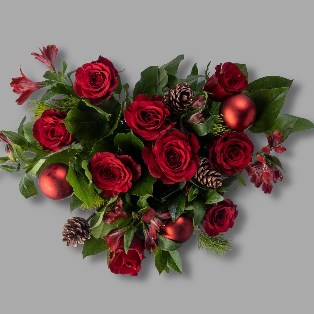 Top down view of Red roses christmas bliss flower bouquet with baubles