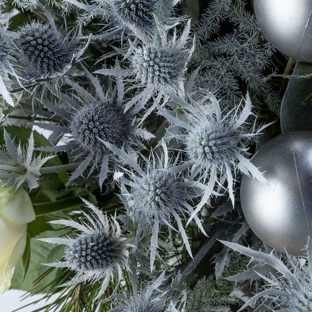 Close up view of thistle from White roses christmas frosty flower bouquet with baubles