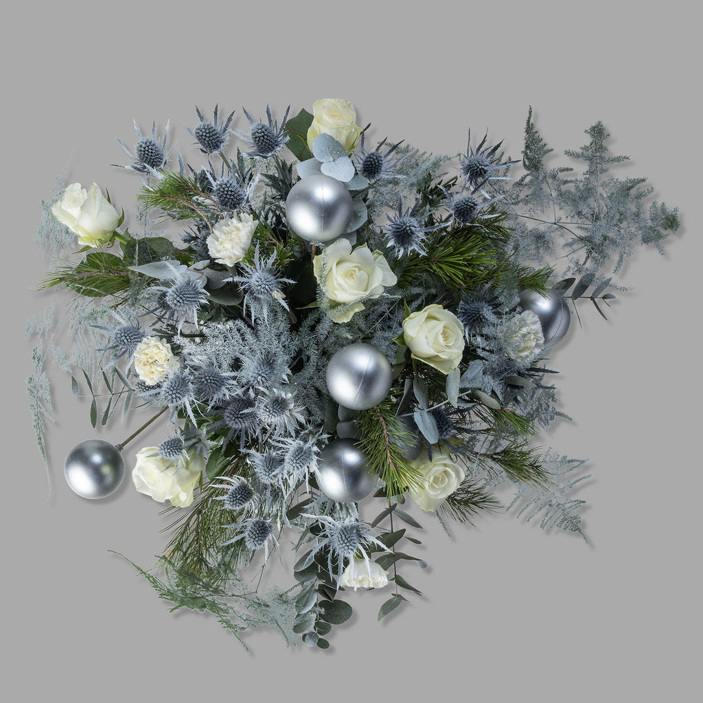 Top down view of white roses christmas frosty flower bouquet with baubles