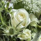 Close up of a white rose from Sea spray flower bouquet in a glass vase
