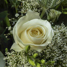 Close up of a rose from Sea spray flower bouquet in a glass vase