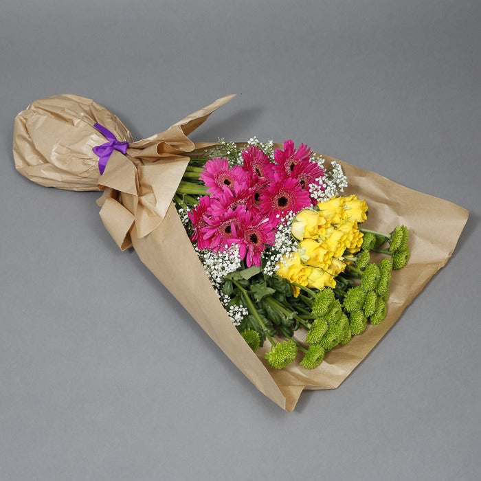 Assortment of flowers arranged in a brown paper bag