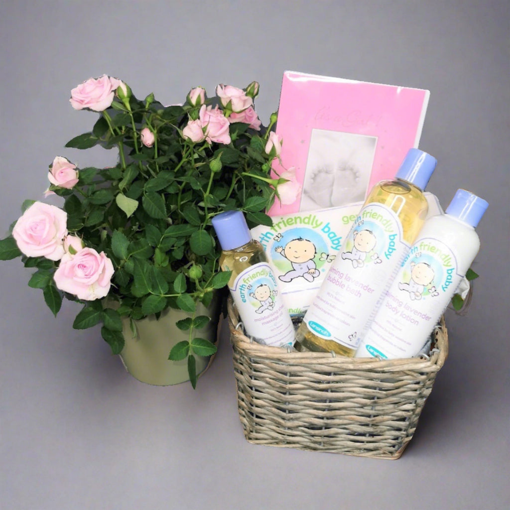Gift hamper for a new-born baby girl with flowers, baby oils and a card