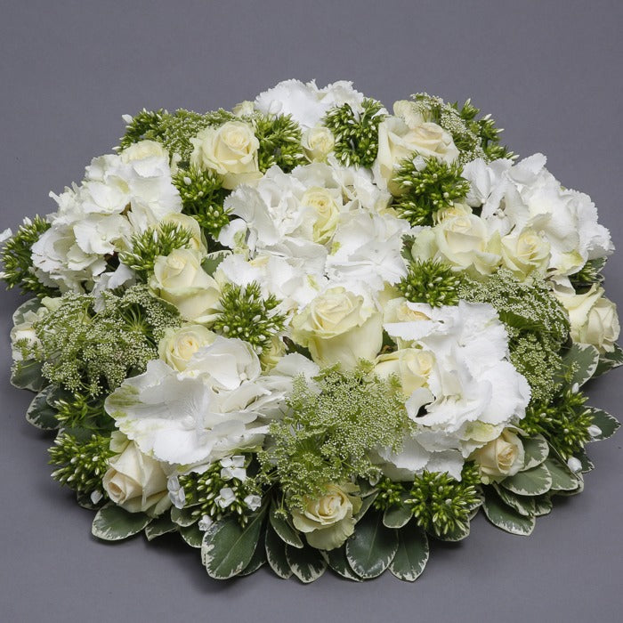 Side angle view of white funeral wreath