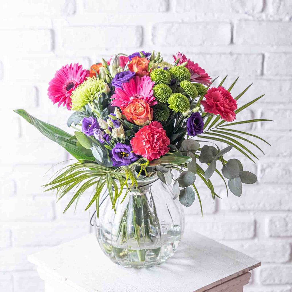 Lifestyle picture of Rainbows flower bouquet in a glass vase